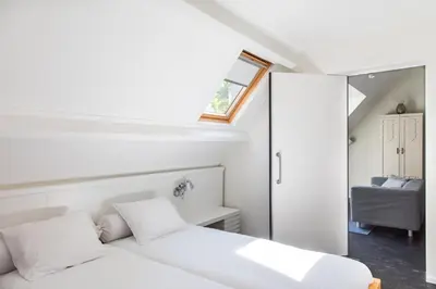 a white bedroom with a bed and a mirror at Villa 1913 in Bergen
