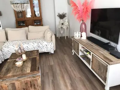 a living room with a couch and a flat screen tv at Pension Hendriks in Zandvoort