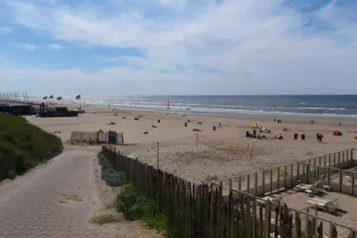 a beach with people on it and the ocean at Pension Hendriks in Zandvoort