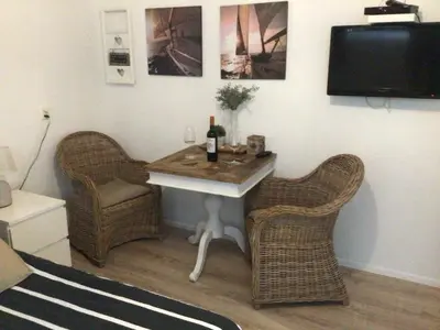 a room with a table with two chairs and a tv at Pension Hendriks in Zandvoort