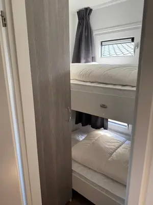 a room with two bunk beds and a window at Chalet Duinpan in IJmuiden