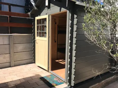 an open door of a shed with a porch at Chalet Duinpan in IJmuiden
