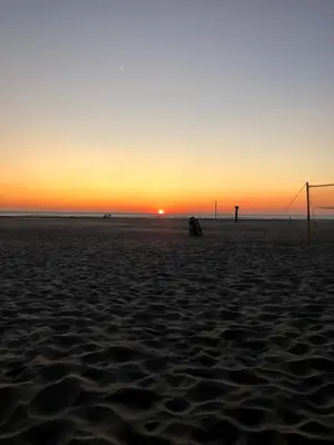 a sunset on a beach with a soccer goal at Chalet Duinpan in IJmuiden