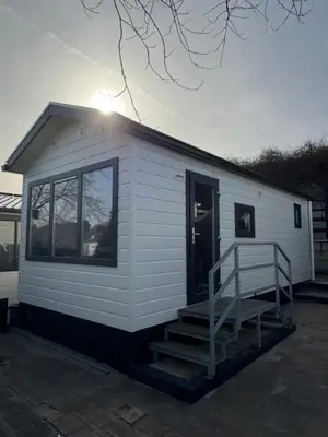 a small white building with a staircase on it at Chalet Duinpan in IJmuiden