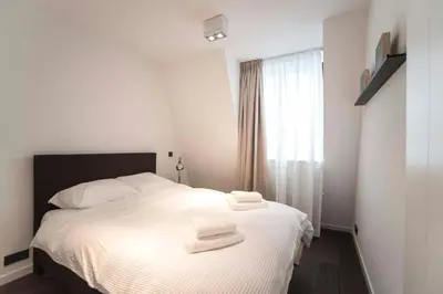 a bedroom with a white bed with towels on it at Sack-Time fashion boutique hotel in Zandvoort
