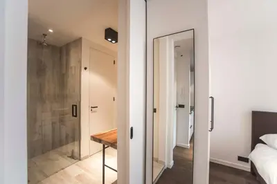 a bedroom with a mirror and a bed and a bathroom at Sack-Time fashion boutique hotel in Zandvoort