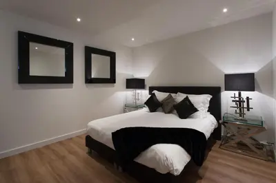 a bedroom with a bed and two mirrors on the wall at Lage Wurft Beach Apartments in Noordwijk