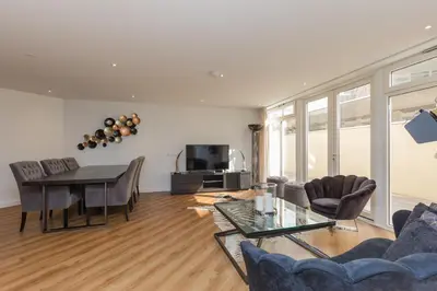 a living room with a table and chairs and a couch at Lage Wurft Beach Apartments in Noordwijk