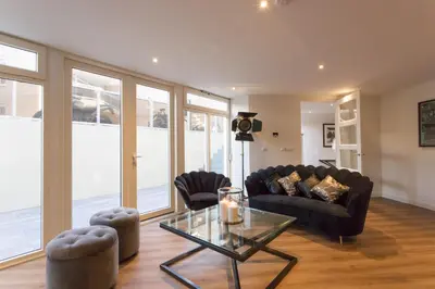 a living room with a couch and a glass table at Lage Wurft Beach Apartments in Noordwijk