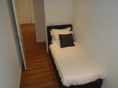 a small bedroom with a bed with a pillow on it at Lage Wurft Beach Apartments in Noordwijk