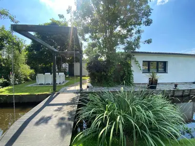 a wooden walkway in front of a house at Bungalow Haarlem Amsterdam with jacuzzi in Vijfhuizen