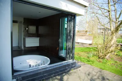 a bathroom with a bath tub in a yard at Bungalow Haarlem Amsterdam with jacuzzi in Vijfhuizen