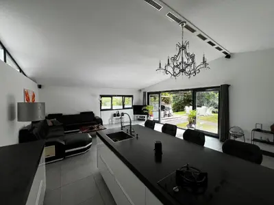 a kitchen and living room with a chandelier at Bungalow Haarlem Amsterdam with jacuzzi in Vijfhuizen