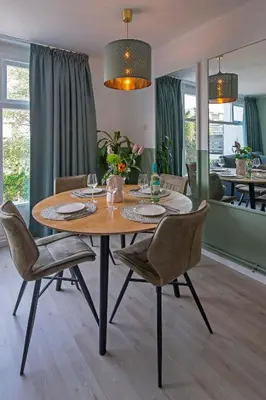 a wooden table with chairs and a dining room at Amsterdam Beach Apartment 65 in Zandvoort