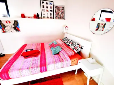 a white bedroom with a bed with a pink blanket at La Corte Sconta B&B in Amsterdam