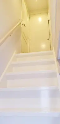 a set of stairs leading to a door in a room at Egmont op zee in Egmond aan Zee