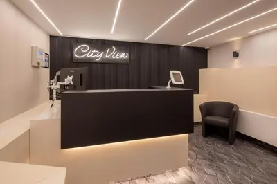 a lobby with a desk and a chair and a sign at Cityview Hotel in Amsterdam