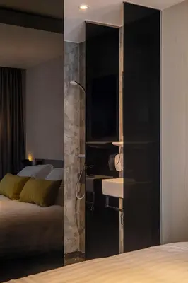 a bedroom with a bed and a bathroom with a shower at Cityview Hotel in Amsterdam