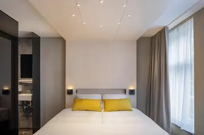 a bedroom with a large bed with yellow pillows at Cityview Hotel in Amsterdam