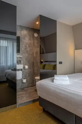 a hotel room with two beds and a mirror at Cityview Hotel in Amsterdam