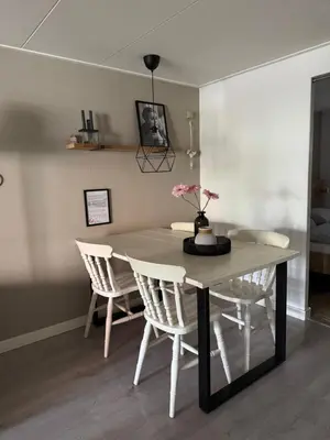 a dining room table with chairs and a vase with flowers on it at Sous aan Zee in Noordwijk