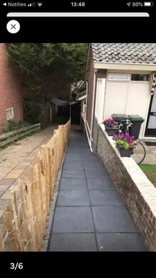 a sidewalk next to a house with a fence and flowers at Sous aan Zee in Noordwijk