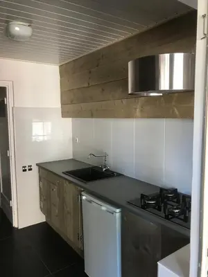 a kitchen with a sink and a stove in it at Sous aan Zee in Noordwijk