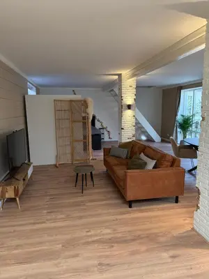 a living room with a couch and a table at Spacious 70m2 apartment in city centre with lovely terrace in Alkmaar
