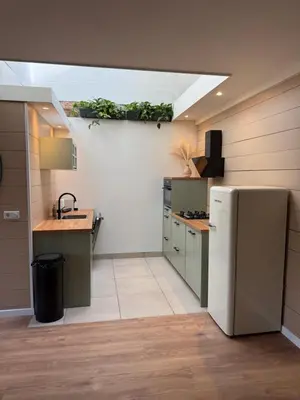 a kitchen with a sink and a refrigerator at Spacious 70m2 apartment in city centre with lovely terrace in Alkmaar