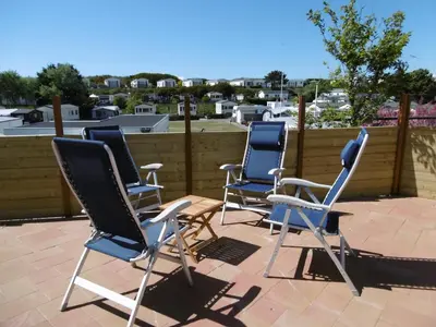 a group of chairs sitting on a patio at Chalet Joleen IJmuiden aan zee, vlakbij het strand in IJmuiden