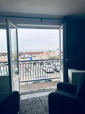a room with an open sliding glass door with a view of an airport at Casa Blanca Zandvoort in Zandvoort