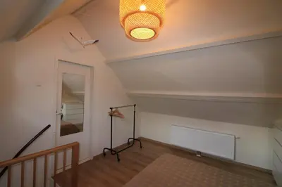 a room with a staircase and a ceiling with a light at De Strandmus in Egmond aan Zee