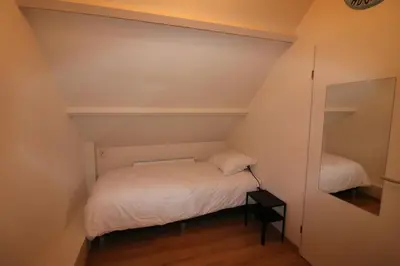 a small room with a bed and a mirror at De Strandmus in Egmond aan Zee