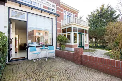 a patio with chairs and a table in front of a building at Happy Home in Zandvoort
