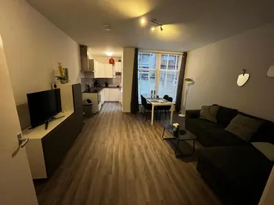 a living room with a couch and a kitchen at Poelgeeststraat in Leiden