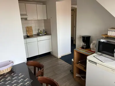 a small kitchen with a table and a microwave at Hotel Noordzee in Zandvoort