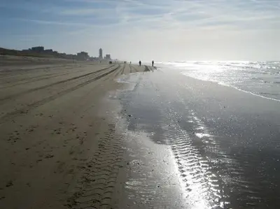a beach with footprints in the sand and the ocean at Continentaiz Appartement in Zandvoort