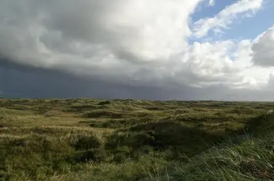 a field of grass with a cloudy sky at Continentaiz Appartement in Zandvoort