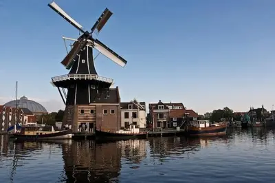 a windmill in the middle of a body of water at Continentaiz Appartement in Zandvoort