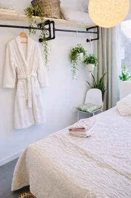 a bedroom with a bed and a robe hanging on a wall at Canal House - Homestay in Alkmaar