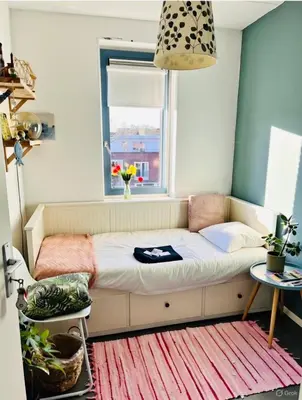 a small bed in a room with a window at Canal House - Homestay in Alkmaar