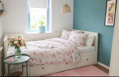 a bedroom with a bed with a vase of flowers at Canal House - Homestay in Alkmaar