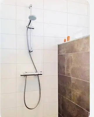 a shower with a shower head on a wall at Canal House - Homestay in Alkmaar