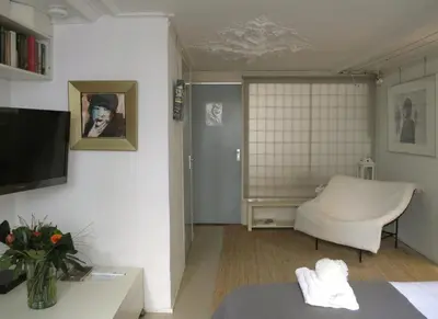 a living room with a couch and a chair at B&B Singel 100 in Amsterdam