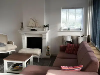 a living room with a couch and a fireplace at Apartment in Noordwijk near North Sea Beach in Noordwijk