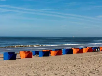 a row of colorful beach chairs on the beach at Apartment in Noordwijk near North Sea Beach in Noordwijk