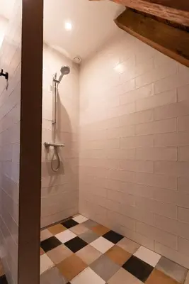 a bathroom with a shower and a checkered floor at B&B Appartement Hemels in Twisk
