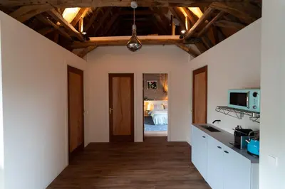 a kitchen with white walls and wooden ceilings at B&B Appartement Hemels in Twisk