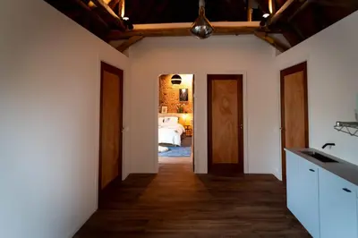 a kitchen with white walls and wooden ceilings at B&B Appartement Hemels in Twisk