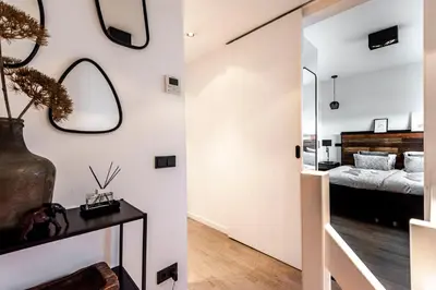 a room with a bed and a mirror on the wall at Sack-Time fashion boutique hotel 6 & 7 in Zandvoort